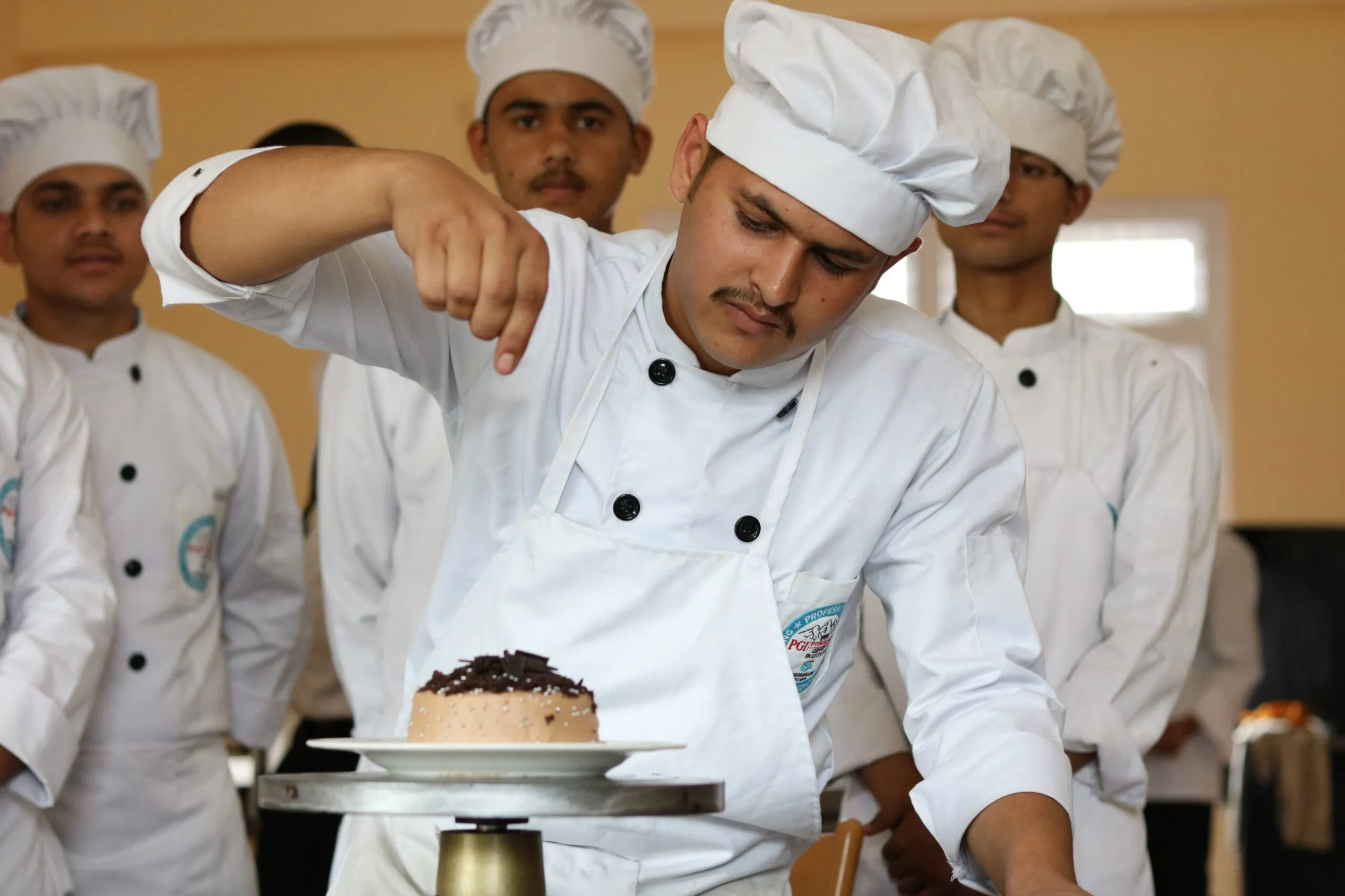 Students icing a cake in the bakery practical
