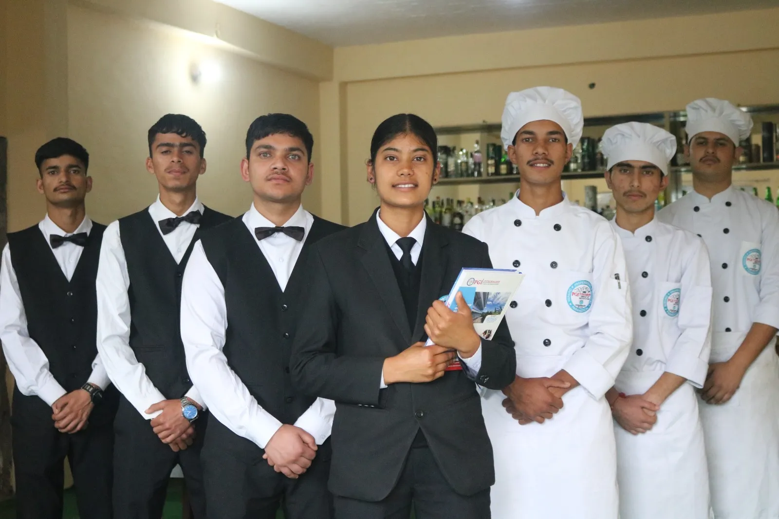 Hotel management students in service and kitchen uniform